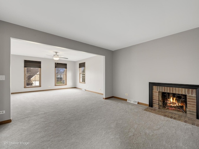 unfurnished living room with a fireplace, carpet flooring, and ceiling fan