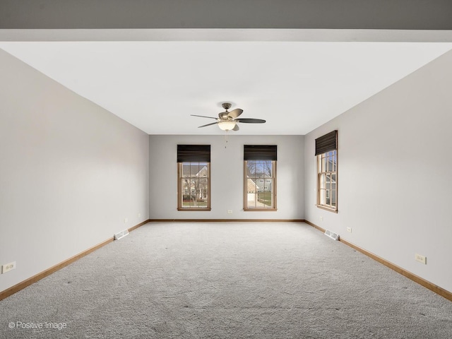 carpeted spare room featuring ceiling fan