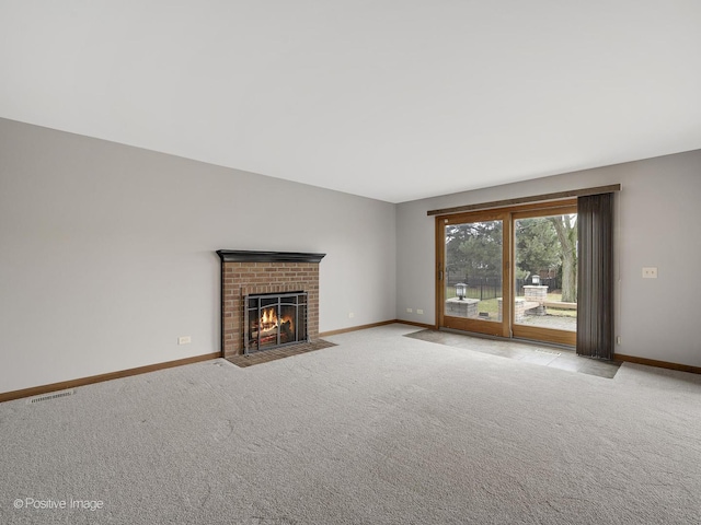 unfurnished living room featuring light colored carpet and a brick fireplace