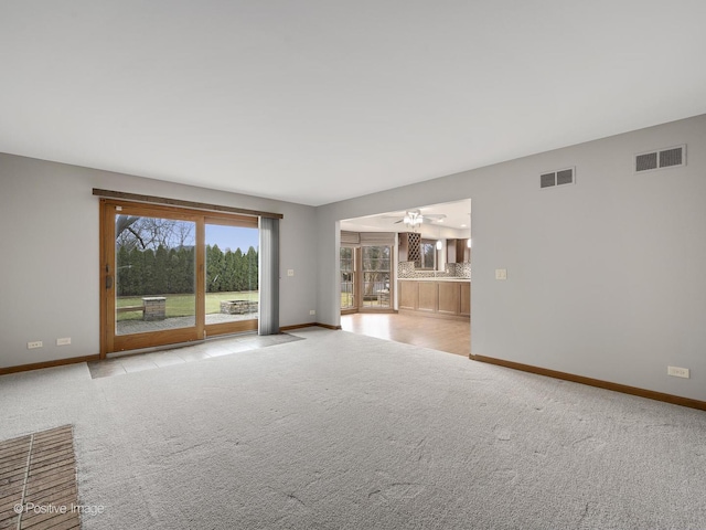 unfurnished living room with ceiling fan and light colored carpet