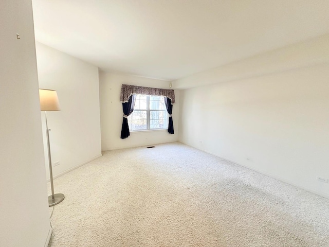 carpeted empty room with baseboards and visible vents