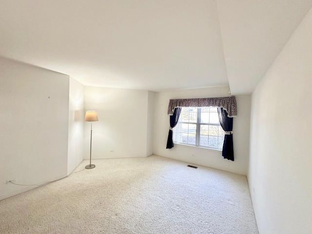 carpeted spare room featuring visible vents