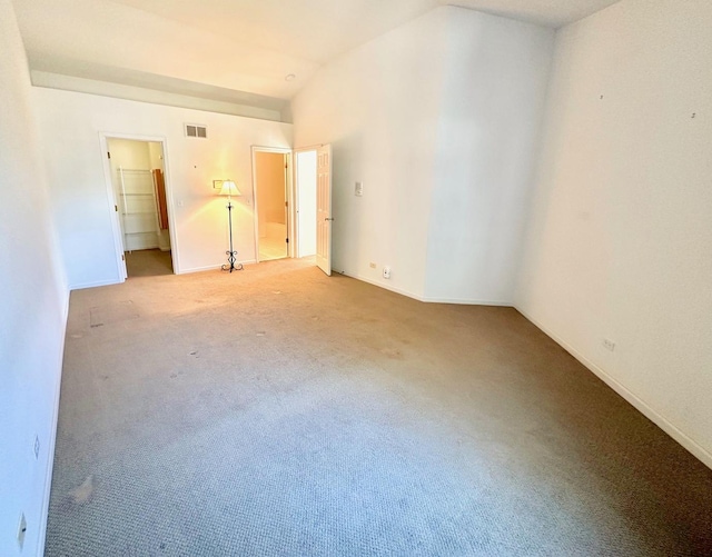 unfurnished bedroom with vaulted ceiling, carpet, visible vents, and baseboards