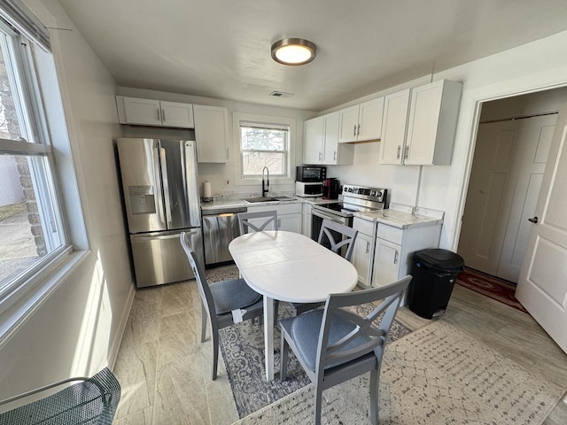 kitchen with white cabinets, appliances with stainless steel finishes, and sink