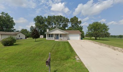 ranch-style home with covered porch, a front yard, and a garage