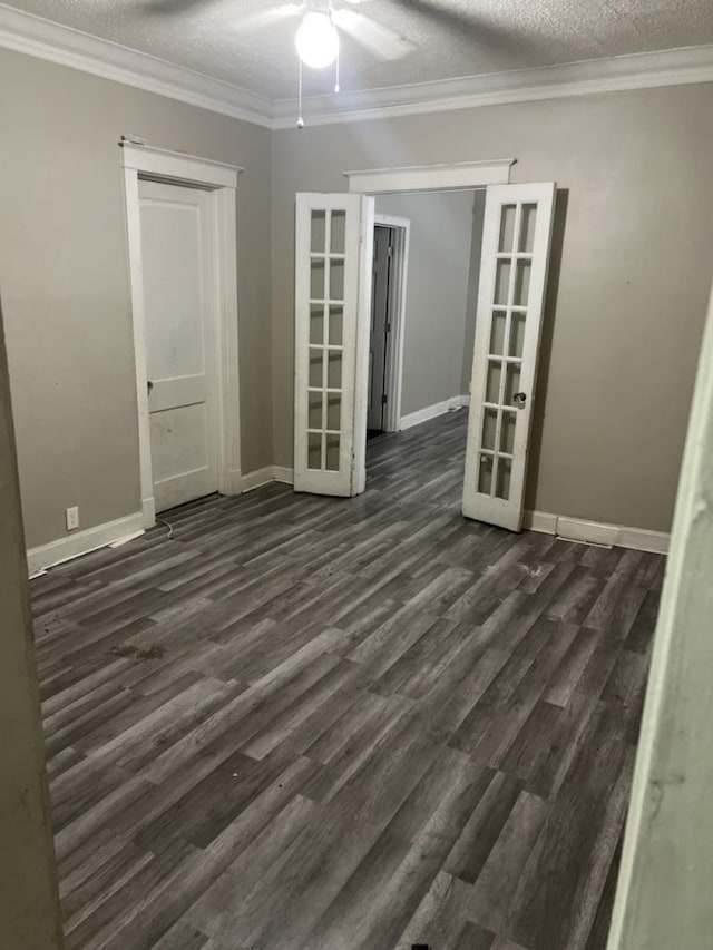 spare room featuring french doors, ornamental molding, a textured ceiling, ceiling fan, and dark wood-type flooring