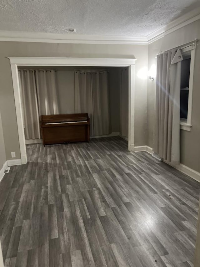 interior space featuring dark hardwood / wood-style floors, a textured ceiling, and ornamental molding