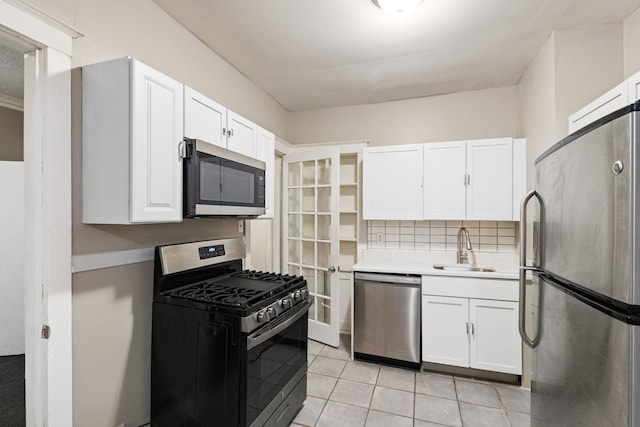 kitchen featuring sink, light tile patterned floors, tasteful backsplash, white cabinets, and appliances with stainless steel finishes