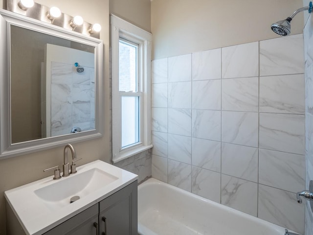 bathroom with tiled shower / bath combo and vanity