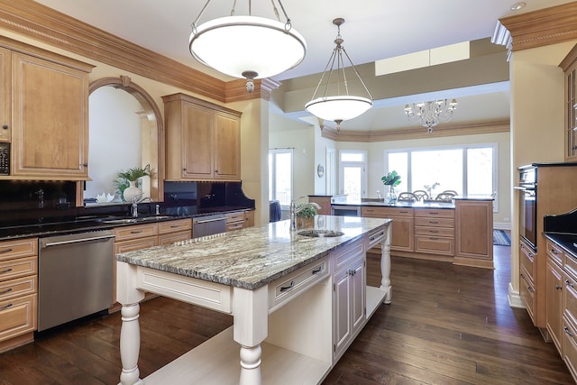 kitchen with light stone countertops, dishwasher, decorative backsplash, and a kitchen island