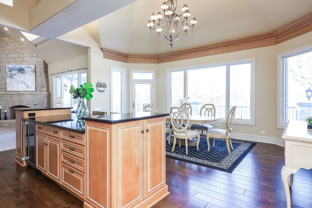 kitchen with dark hardwood / wood-style flooring, an inviting chandelier, beverage cooler, and a center island