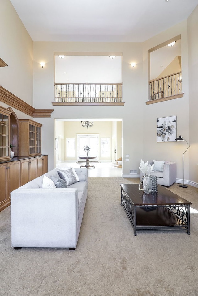 carpeted living room with a high ceiling