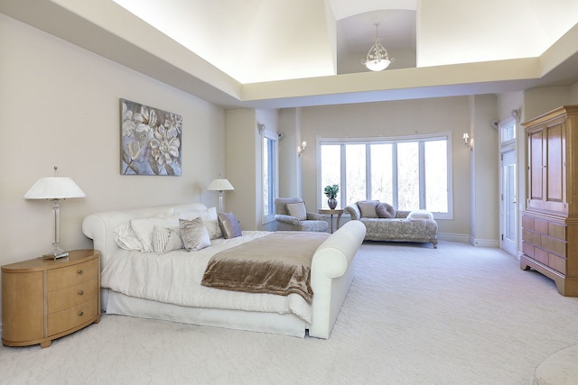 carpeted bedroom with a high ceiling and an inviting chandelier