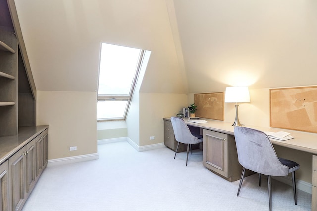 carpeted home office featuring lofted ceiling and built in desk