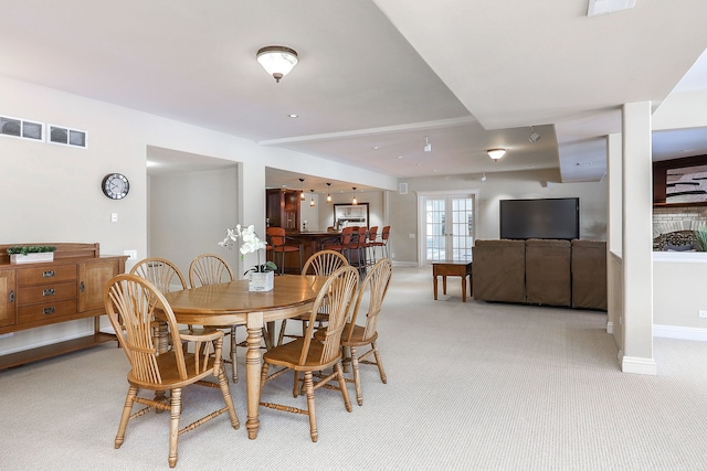 dining room featuring french doors and light carpet