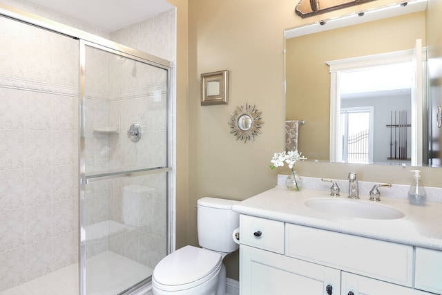 bathroom with walk in shower, vanity, and toilet