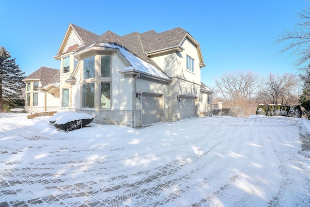 view of snowy exterior with a garage