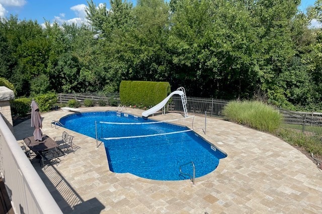 view of swimming pool with a patio, a diving board, and a water slide