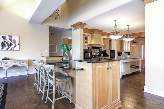 kitchen featuring black oven, decorative light fixtures, premium range hood, and dark wood-type flooring