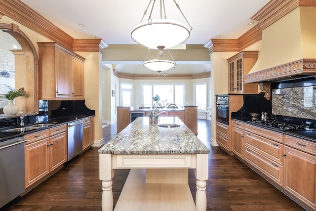 kitchen with a center island with sink, custom exhaust hood, tasteful backsplash, and black appliances