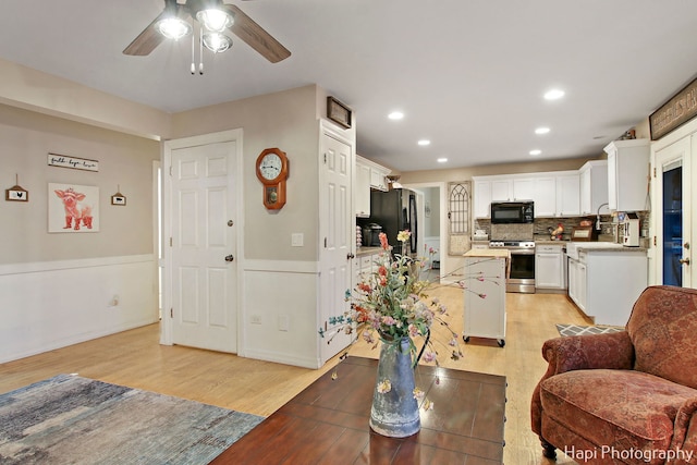 dining area featuring ceiling fan, sink, and light hardwood / wood-style flooring