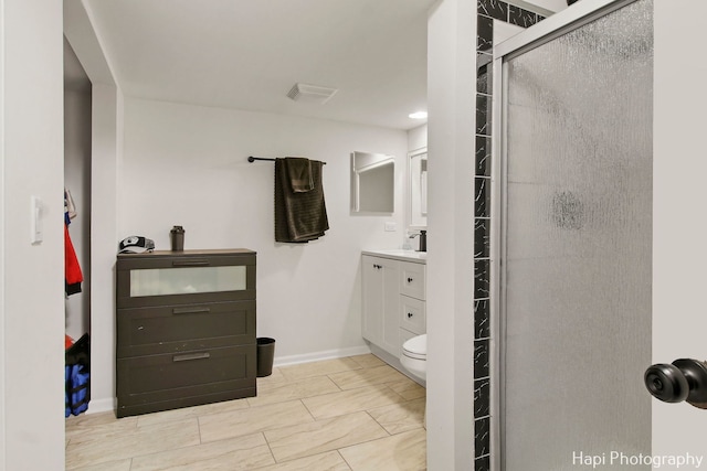 bathroom with vanity, toilet, and a shower with door