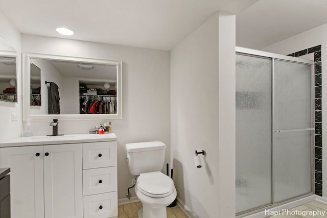 bathroom with vanity, an enclosed shower, and toilet