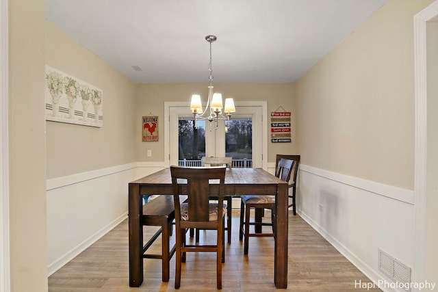 dining room with wood-type flooring and a chandelier