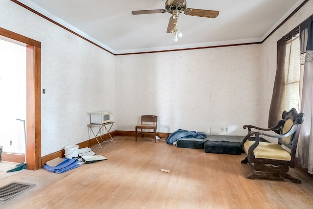 interior space with hardwood / wood-style flooring, ceiling fan, and crown molding