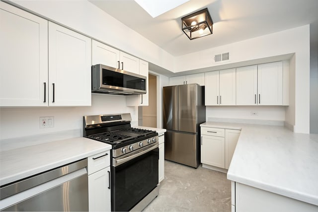 kitchen with white cabinets, stainless steel appliances, and a skylight