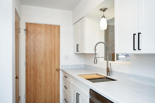 kitchen featuring white cabinetry, hanging light fixtures, and sink