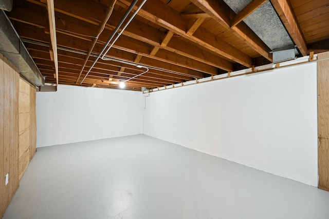 basement featuring wooden walls