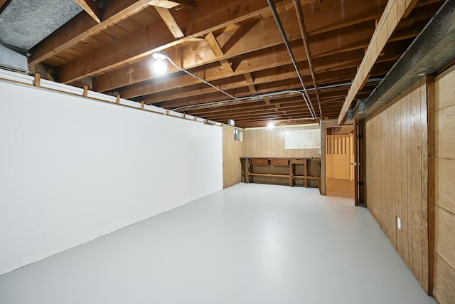 basement featuring wood walls