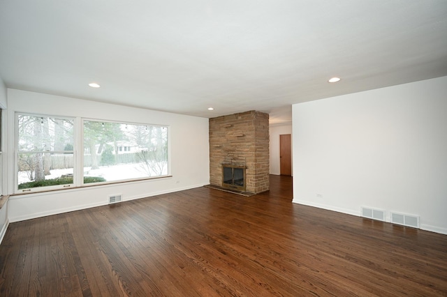 unfurnished living room featuring a fireplace and dark wood-type flooring