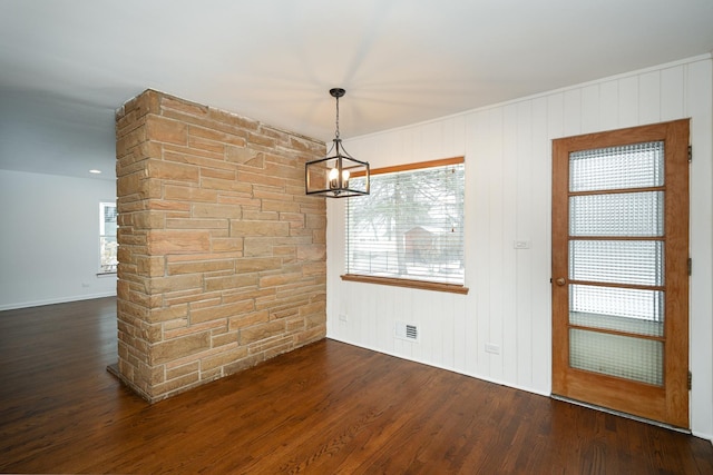 unfurnished dining area featuring a chandelier, dark hardwood / wood-style floors, and plenty of natural light