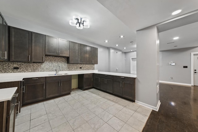 kitchen with backsplash, dark brown cabinets, light tile patterned floors, and sink