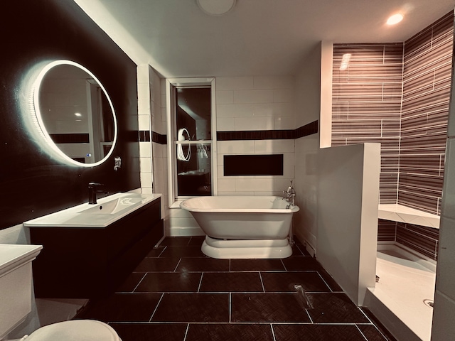 bathroom featuring tile patterned floors, vanity, tile walls, and independent shower and bath