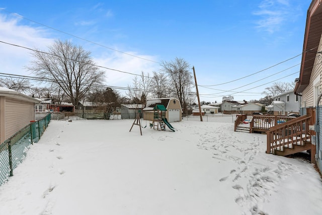 yard layered in snow with a playground