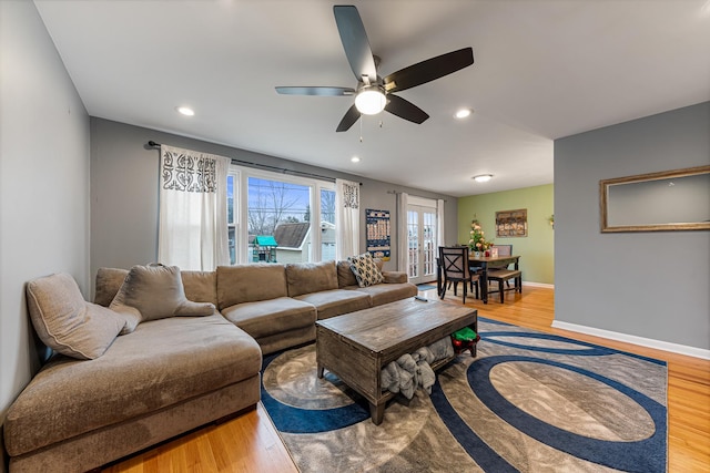 living room with ceiling fan and light hardwood / wood-style flooring