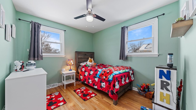 bedroom with multiple windows, ceiling fan, and light wood-type flooring