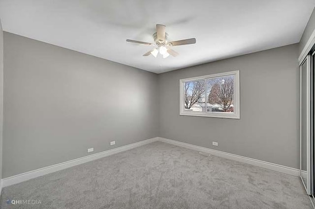 spare room with ceiling fan and light colored carpet