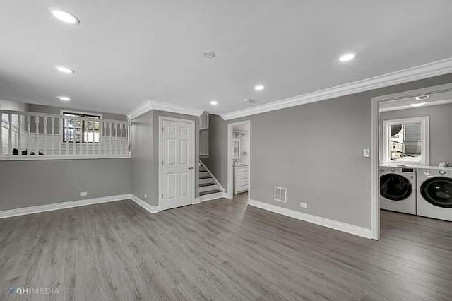 interior space featuring washing machine and dryer, dark wood-type flooring, and ornamental molding