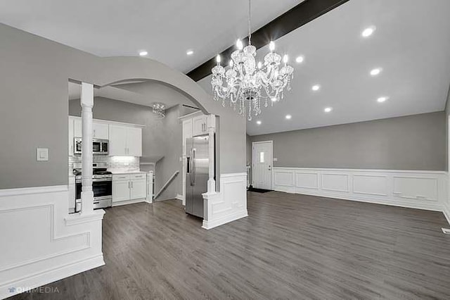 kitchen featuring dark hardwood / wood-style flooring, ornate columns, stainless steel appliances, pendant lighting, and white cabinetry