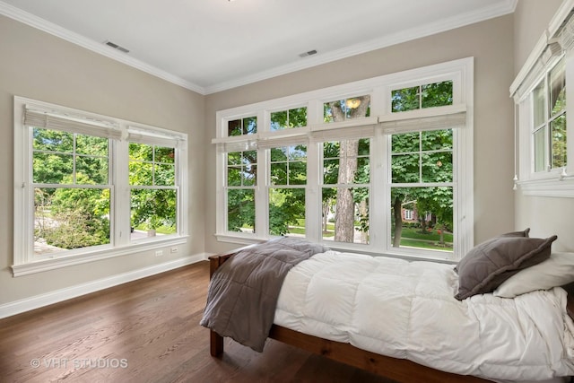 bedroom featuring dark wood-type flooring, multiple windows, and crown molding