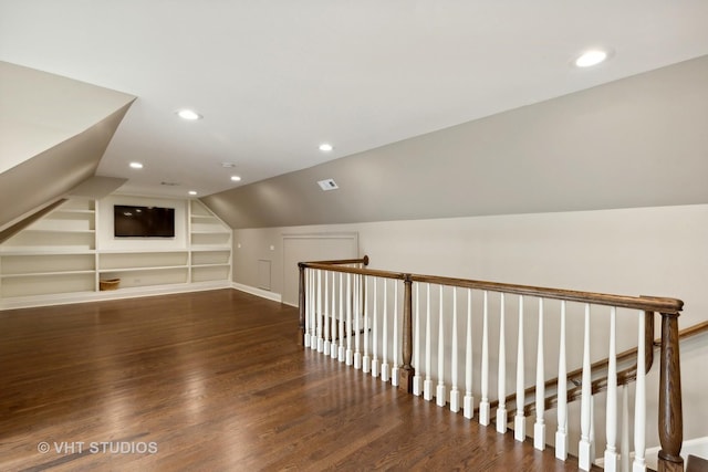 additional living space featuring built in shelves, dark hardwood / wood-style floors, and vaulted ceiling