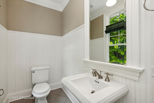 bathroom with sink, toilet, ornamental molding, and tile patterned flooring