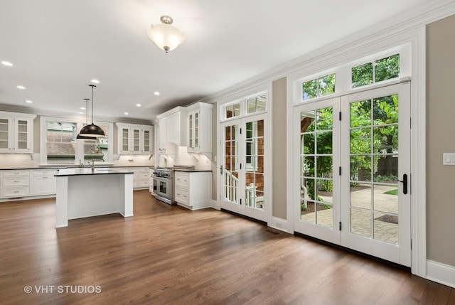 kitchen featuring pendant lighting, white cabinetry, double oven range, backsplash, and dark hardwood / wood-style floors