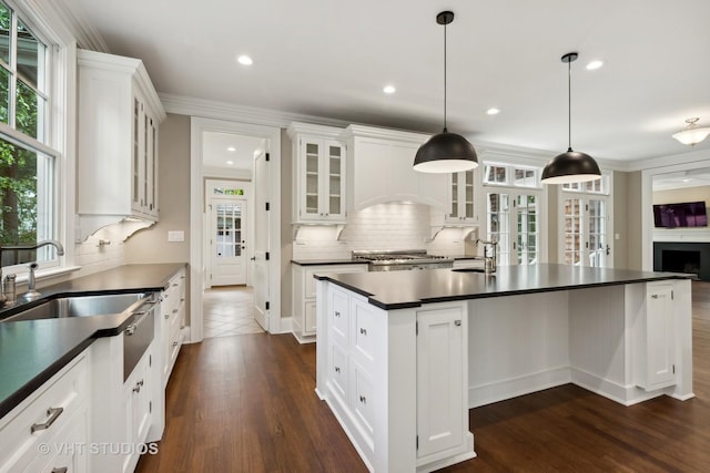 kitchen featuring sink, white cabinetry, pendant lighting, and a kitchen island with sink