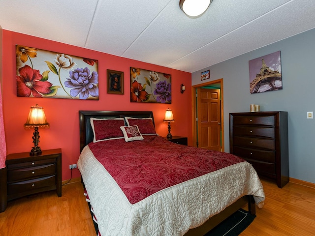 bedroom featuring light wood-type flooring and a textured ceiling