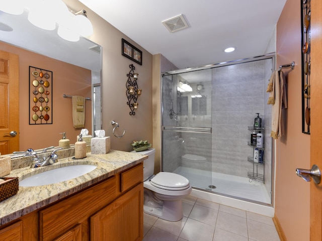 bathroom with tile patterned flooring, vanity, toilet, and walk in shower